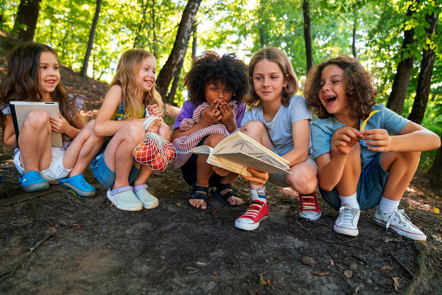 Mehrere Kinder lesen gemeinsam in einem Buch.
