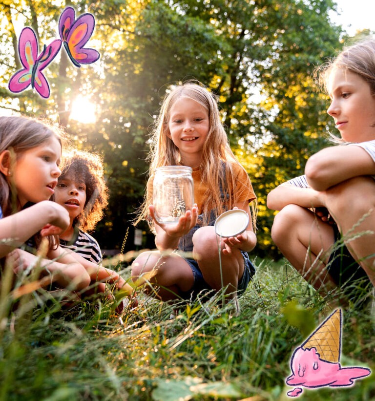 Kinder sitzen im Gras und beobachten fasziniert ein Insekt, das sie mit einem Glas gefangen haben