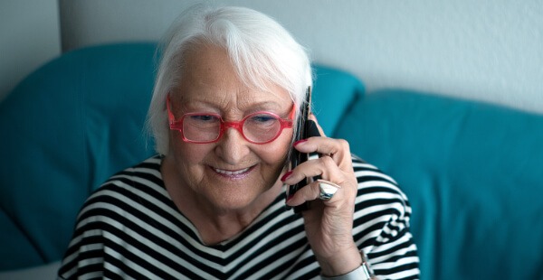 Gut gelaunte Seniorin am Telefon